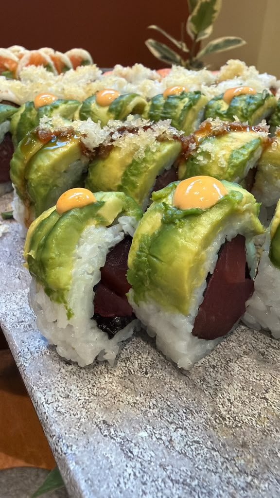 Tuna and avocado sushi rolls on a stone platter